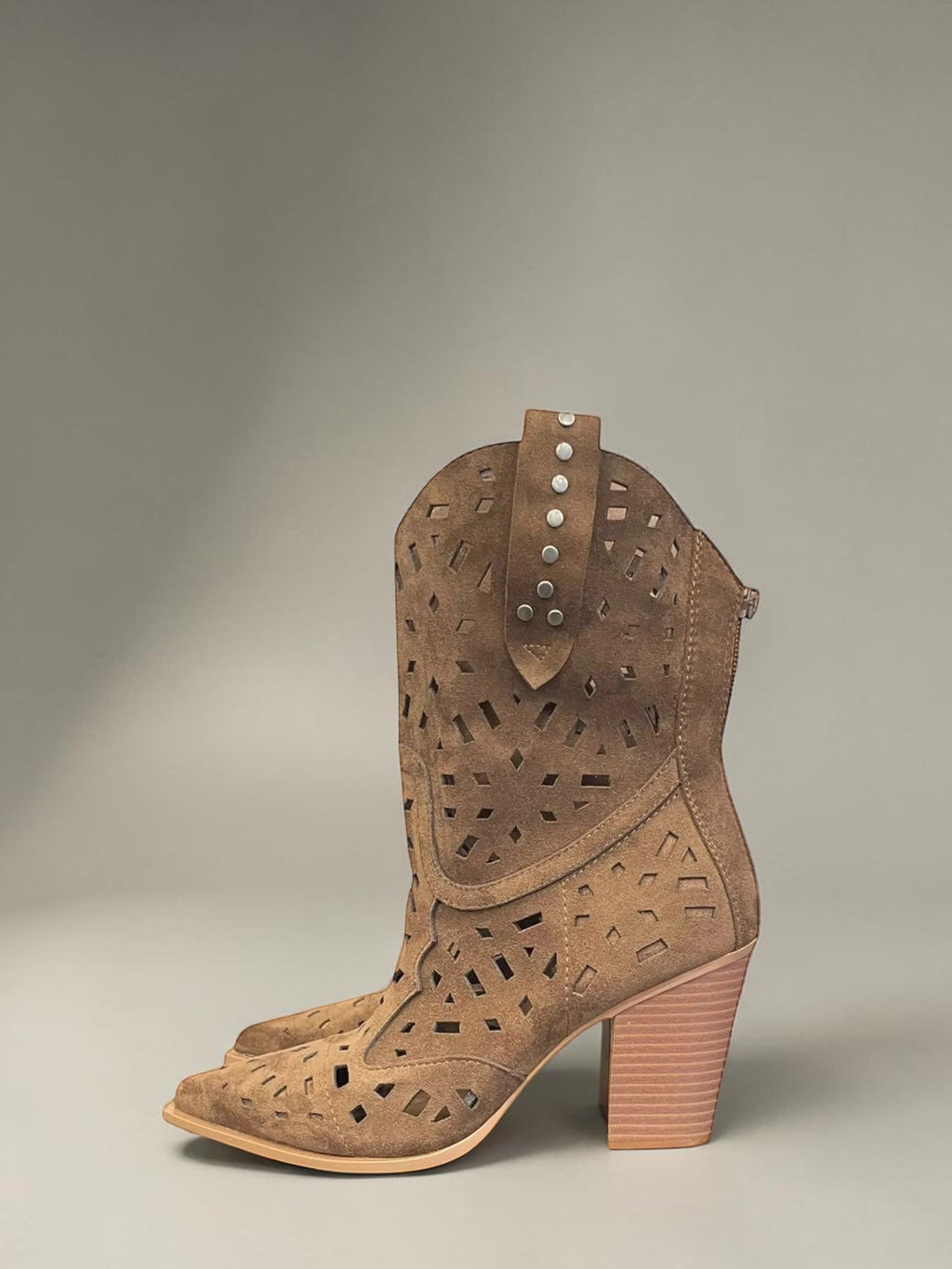 Day One Concept Store tan suede western boots with geometric cutouts, pointed toe, stacked heel, and stud details.