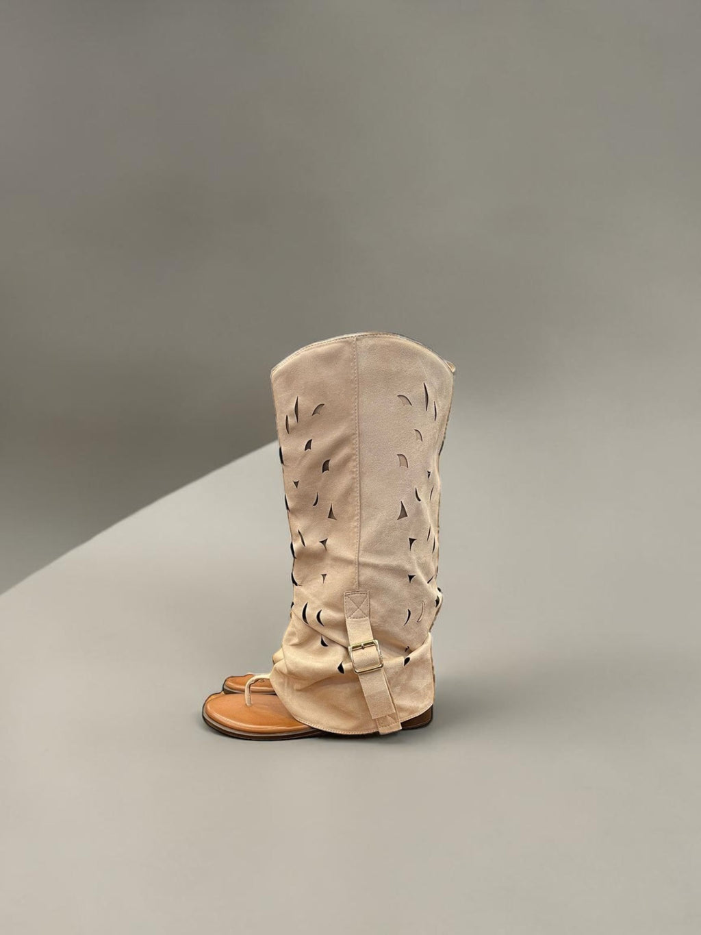 Day One Concept Store beige suede tall boots with cut-out details and buckle strap.