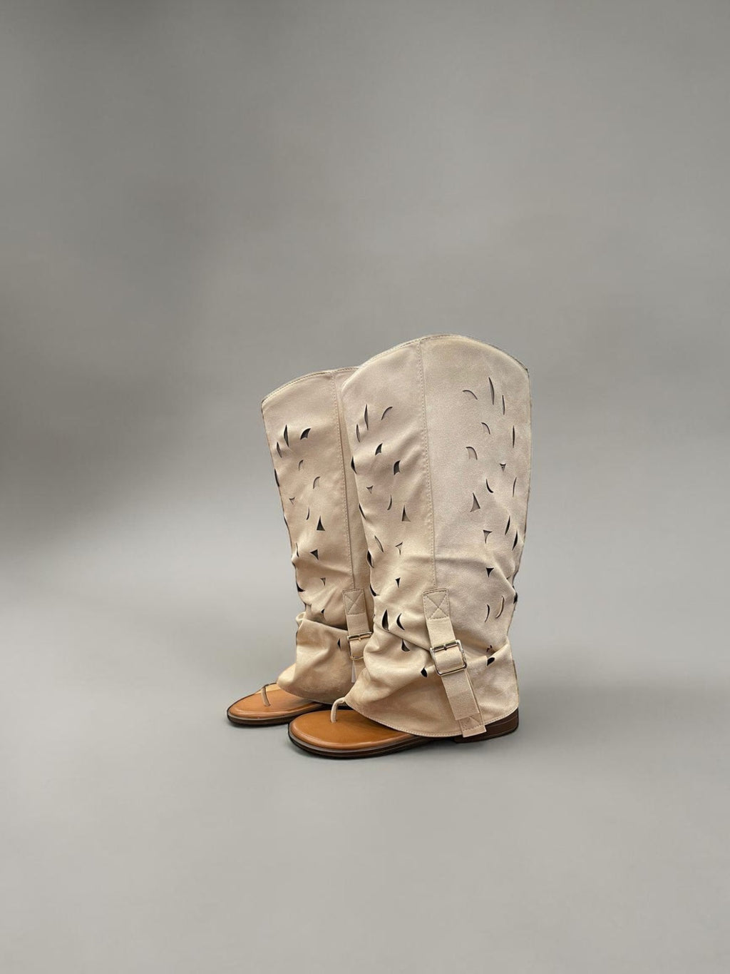 Day One Concept Store beige suede slouchy tall boots with cut-out details and buckle strap.