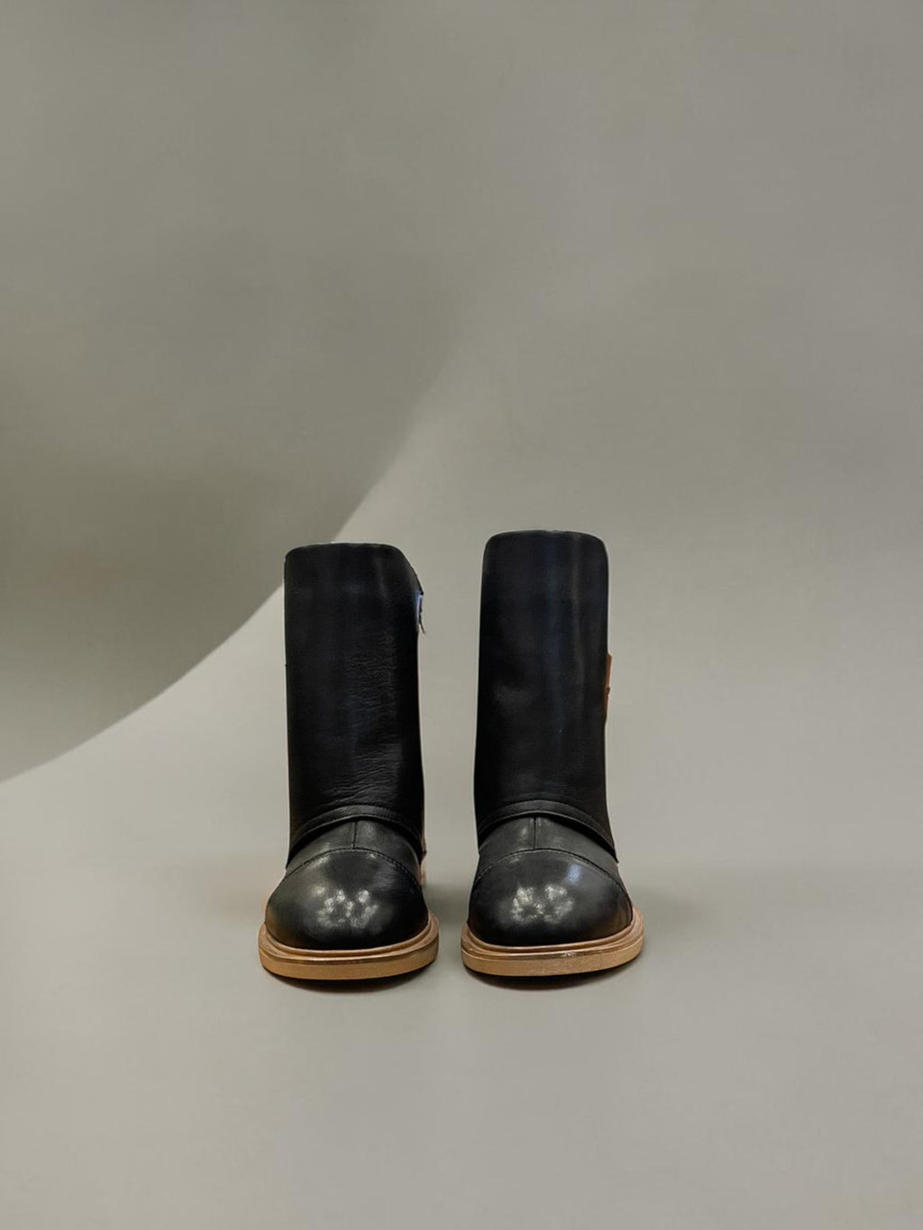 Day One Concept Store black faux leather boots with buckle detail and robust sole. Contemporary rock aesthetic.