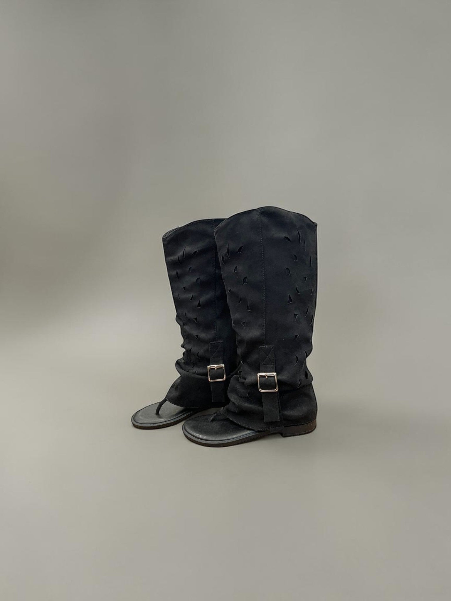 Day One Concept Store black slouchy knee-high boots with cut-out details and side buckle straps.