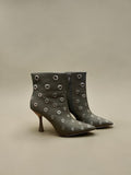 Day One Concept Store black ankle boots with pointed toe, stiletto heel, and all-over silver eyelet details.