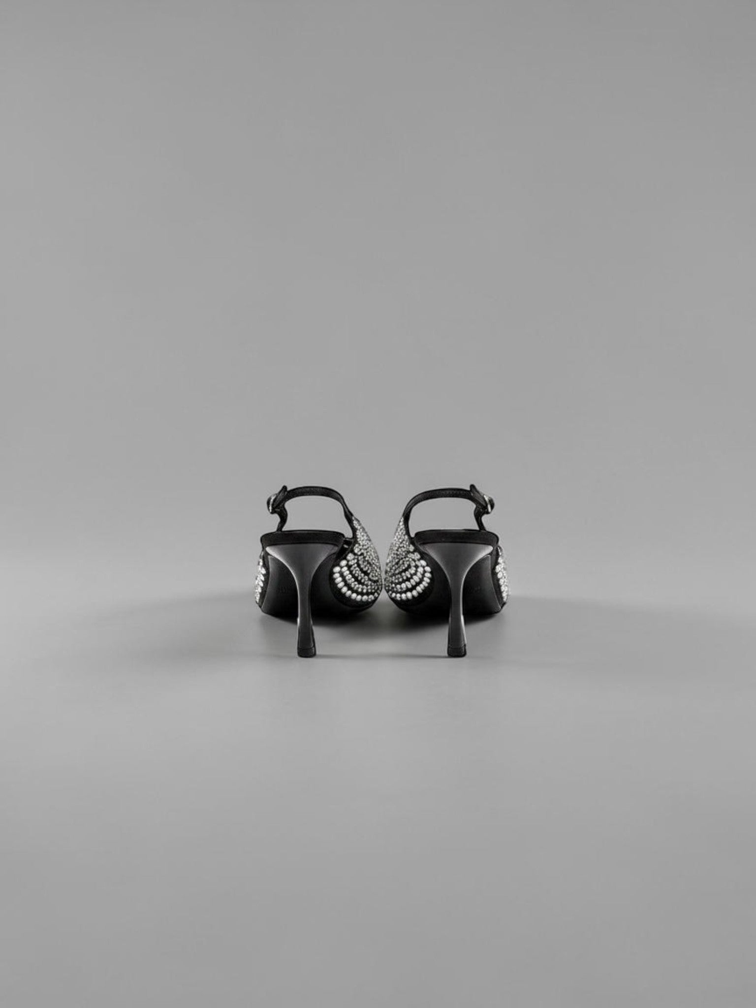 Day One Concept Store black slingback heels with pointed toe and rhinestone embellishments, adjustable ankle strap.