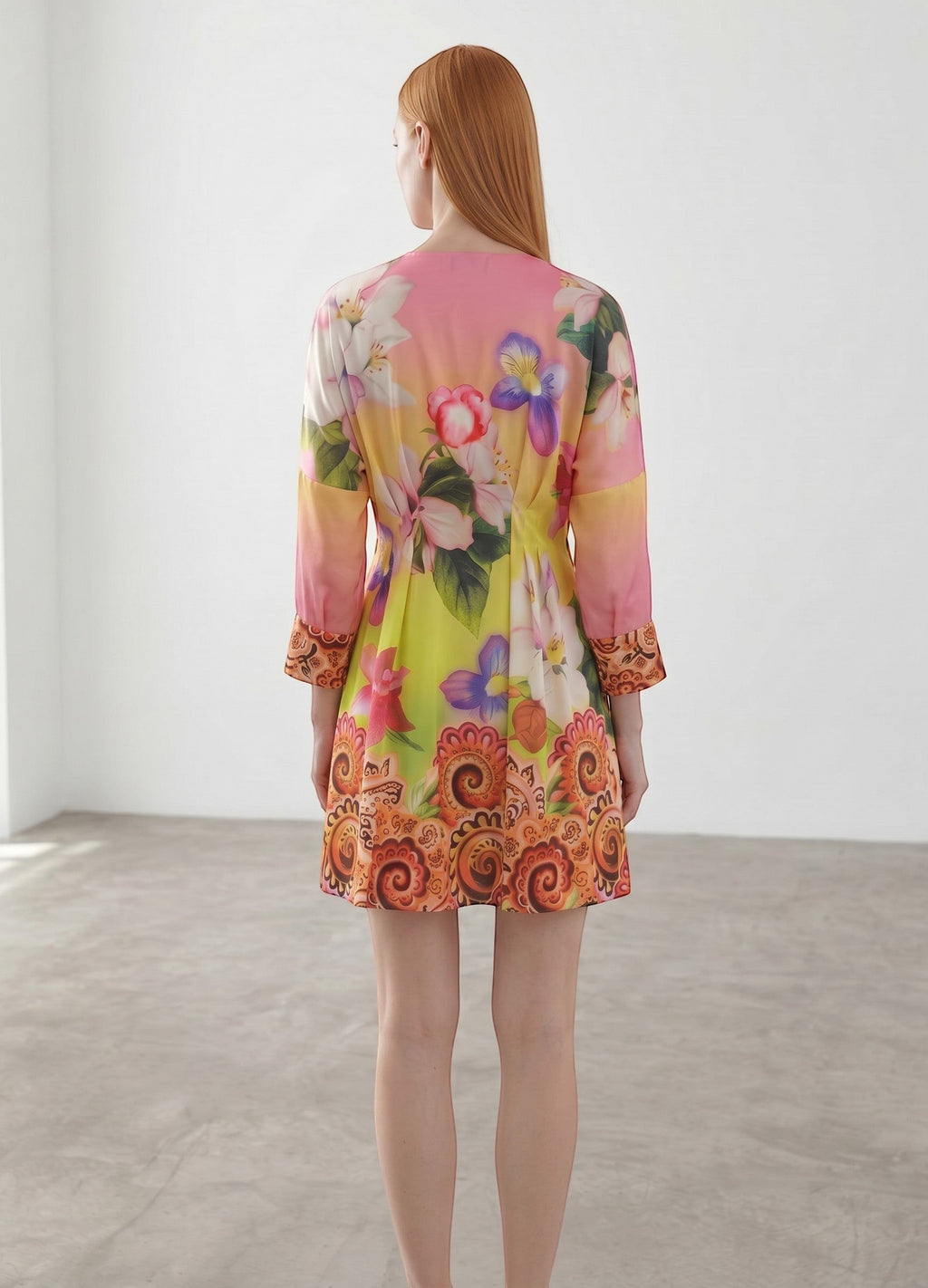 Day One Concept Store vibrant floral print mini dress with V-neck, cinched waist, and paisley border. Lightweight, flowing fabric.