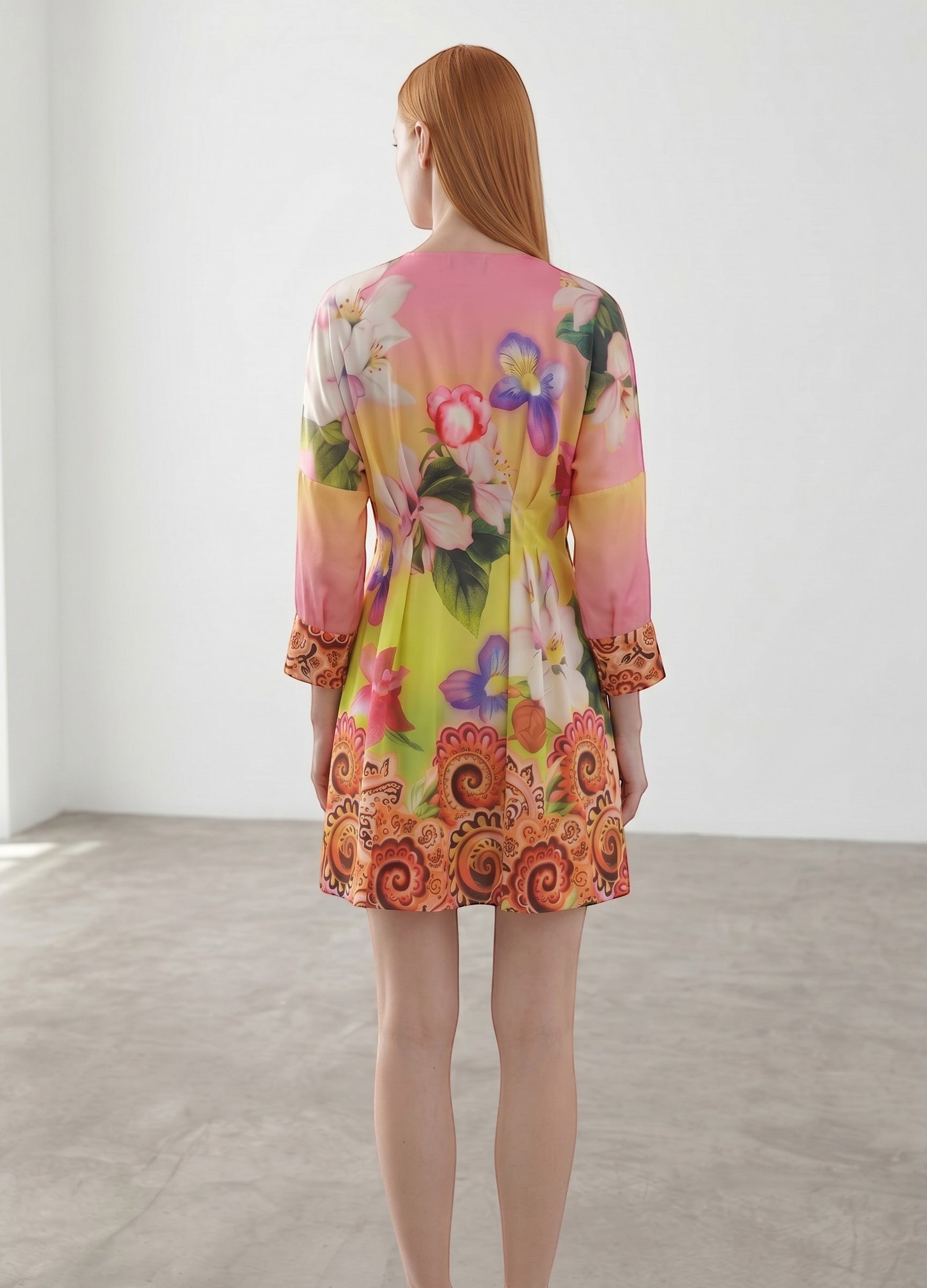Day One Concept Store vibrant floral print mini dress with V-neck, cinched waist, and paisley border. Lightweight, flowing fabric.