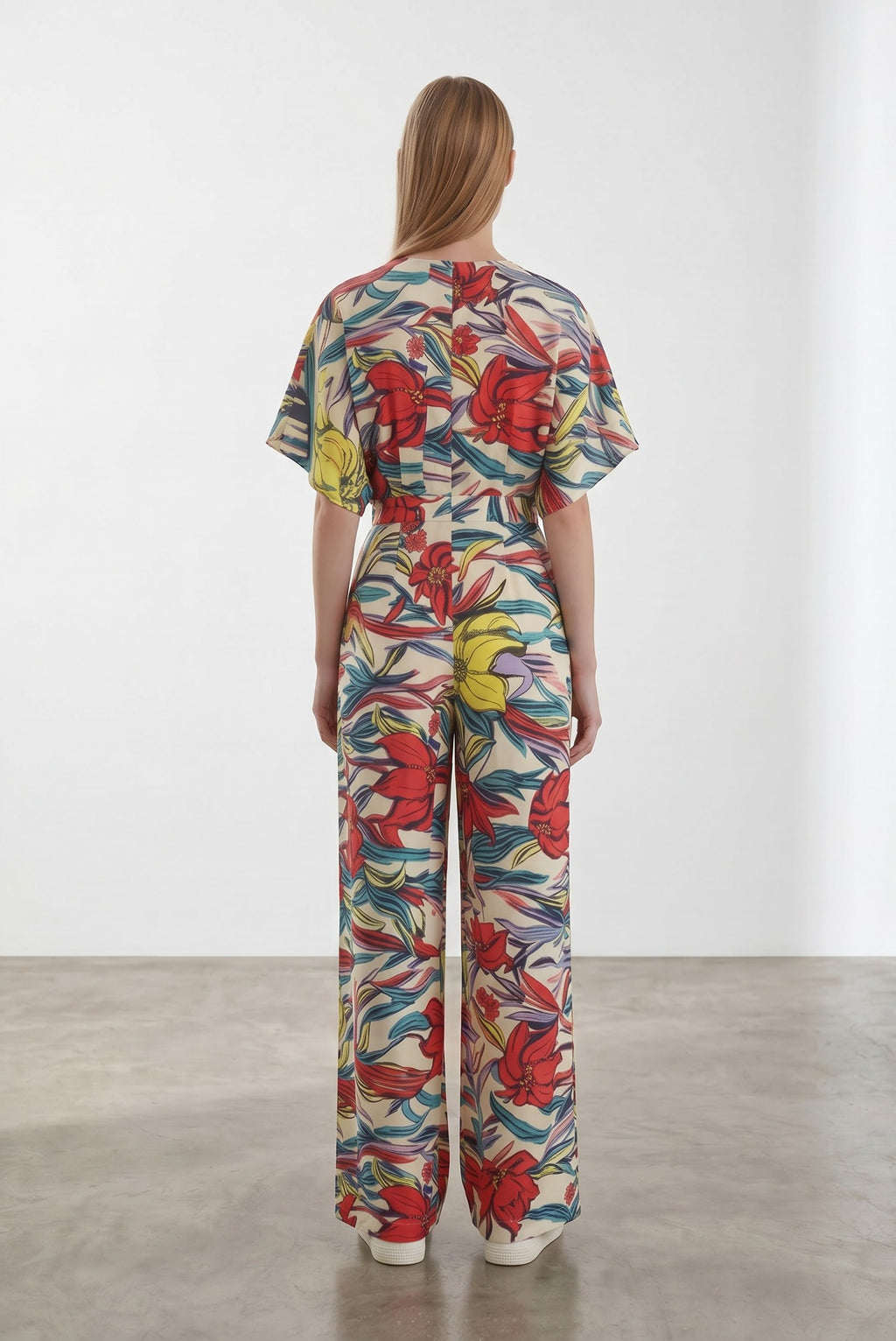 Day One Concept Store cream wide-leg jumpsuit with abstract floral print in red, yellow, and blue, V-neck, and kimono sleeves.