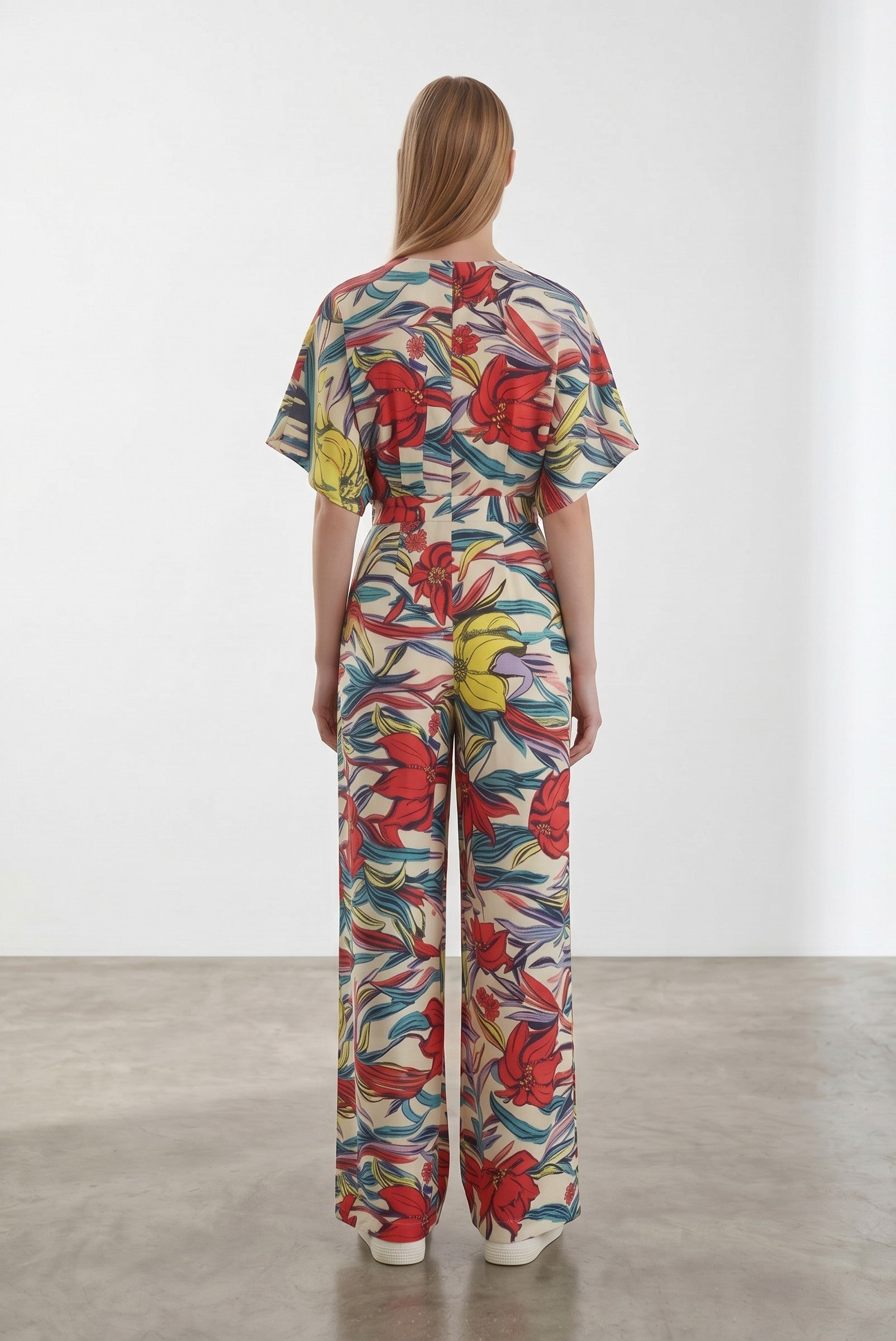 Day One Concept Store cream wide-leg jumpsuit with abstract floral print in red, yellow, and blue, V-neck, and kimono sleeves.