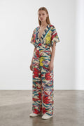 Day One Concept Store cream wide-leg jumpsuit with abstract floral print in red, yellow, and blue, V-neck, and kimono sleeves.