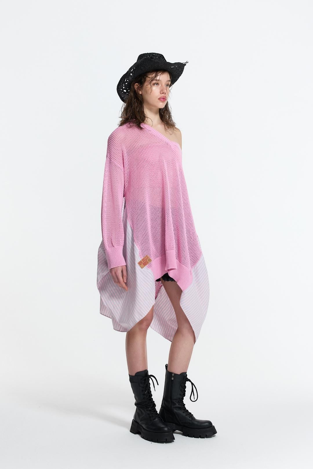 Day One Concept Store pink oversized knit sweater with asymmetric hem and striped fabric insert, worn off-shoulder.