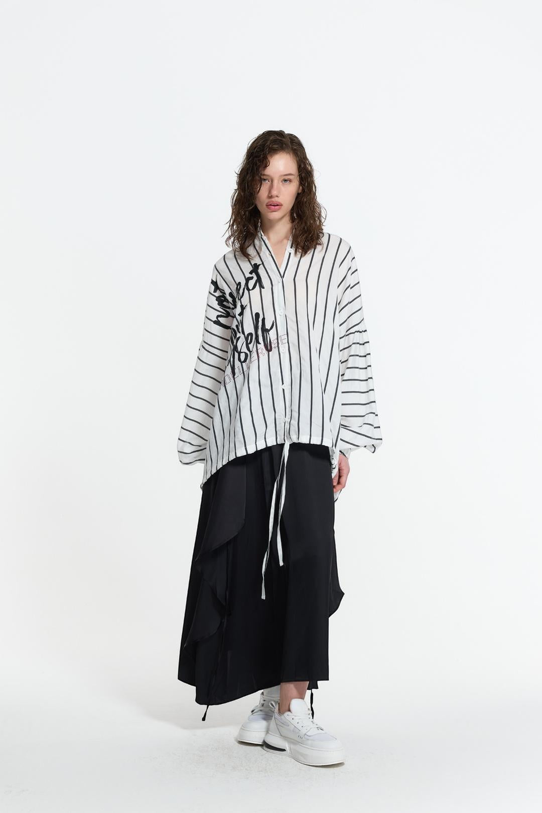 Day One Concept Store white and black striped oversize shirt with graffiti print, V-neck, and wide sleeves.