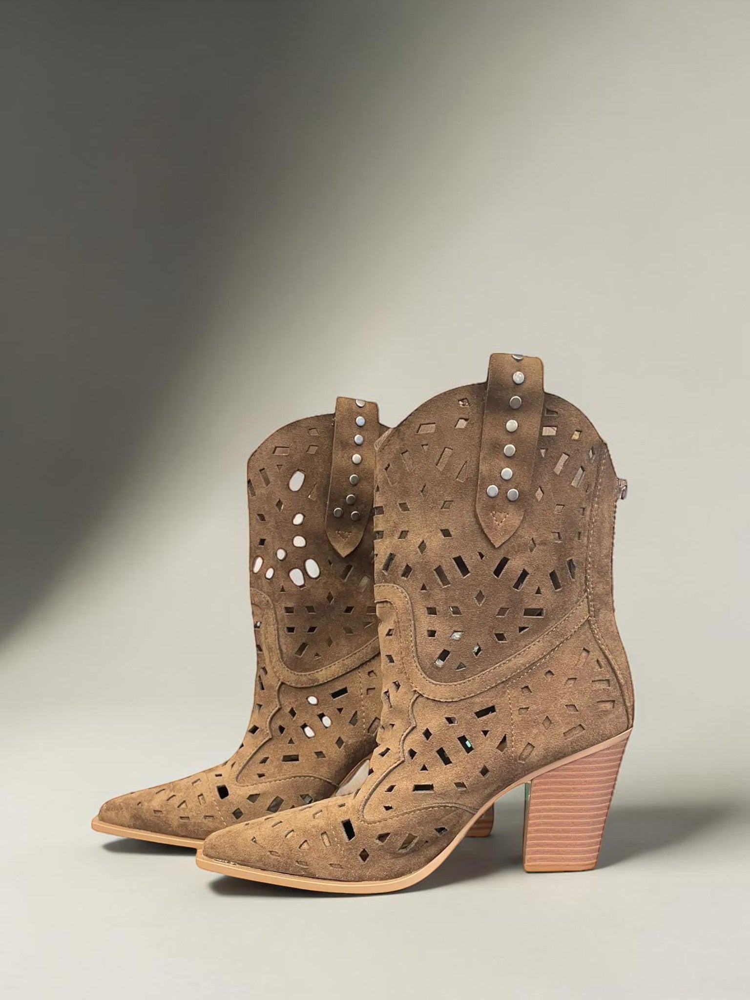 Day One Concept Store tan suede western boots with laser-cut geometric patterns, pointed toe, stacked block heel, and stud embellishments.