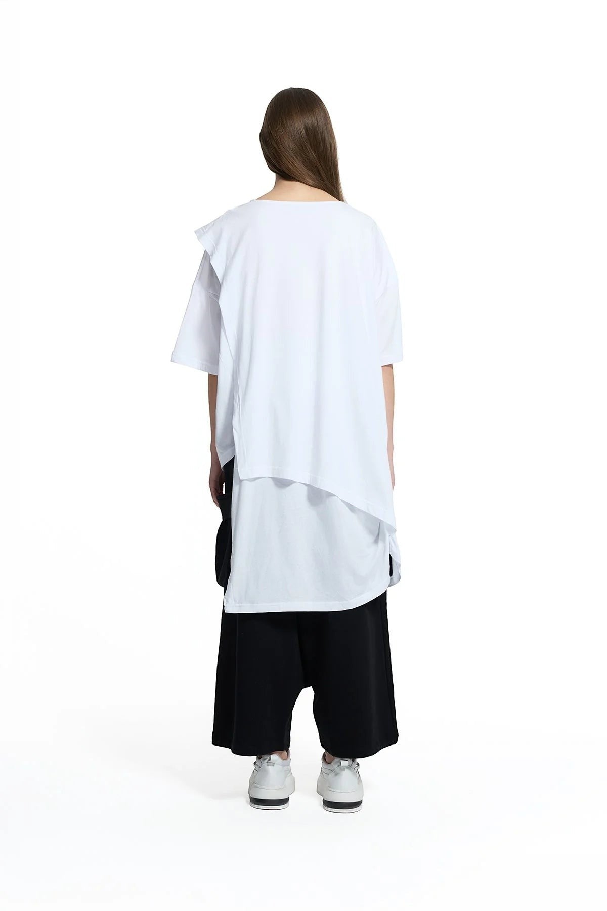 Day One Concept Store white oversized cotton t-shirt with asymmetric layered hem and short sleeves, worn by a model with brown hair.